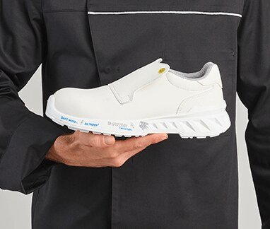 Chaussure de cuisine blanche tenue &agrave; la main par un cuisinier